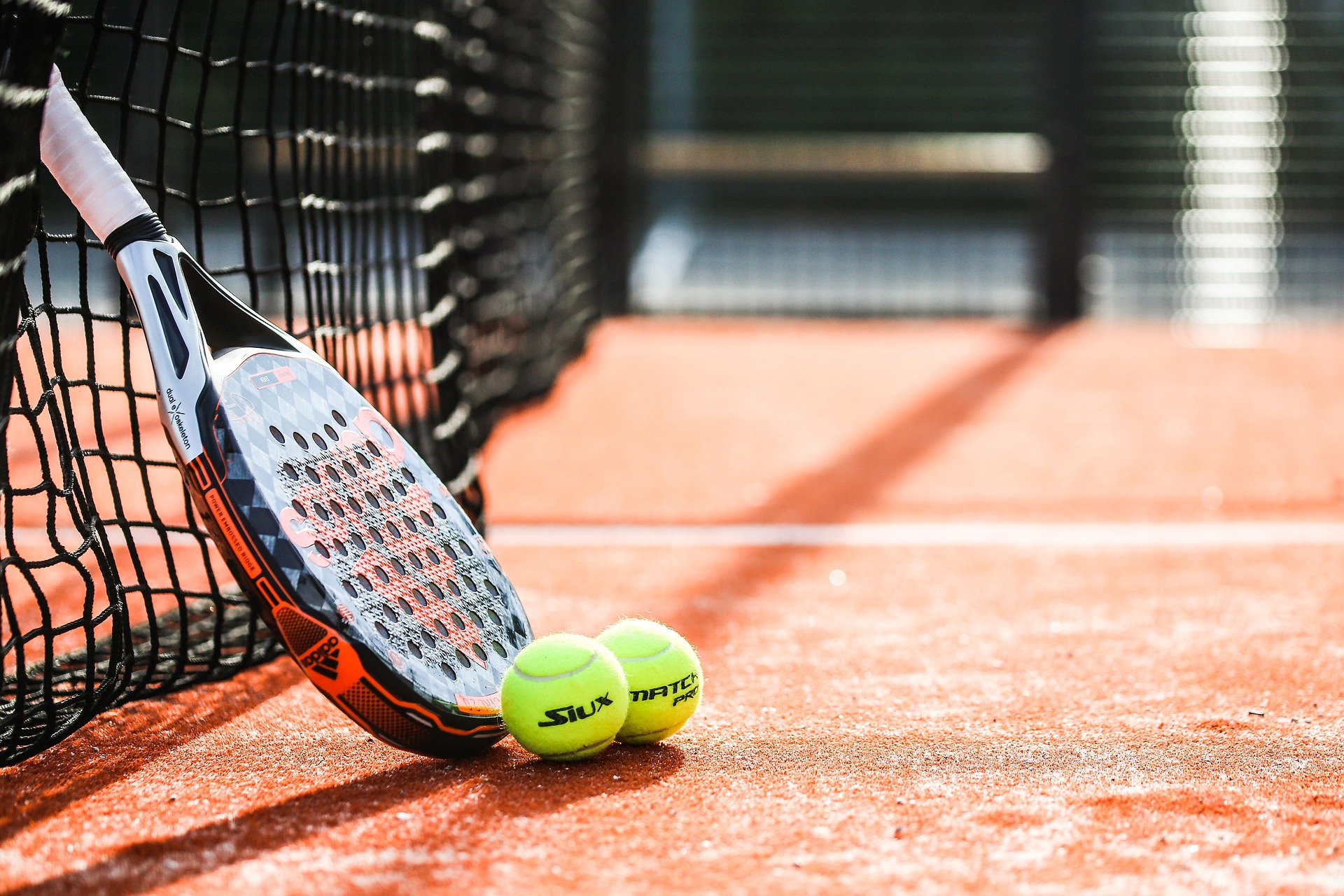 Padel racket and balls on court